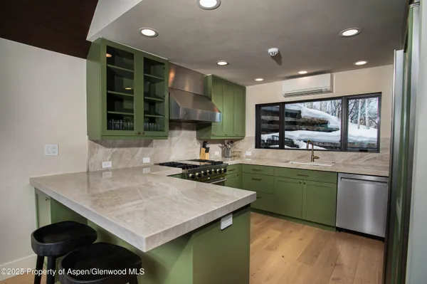 a kitchen with stainless steel appliances granite countertop a sink counter space cabinets and wooden floor