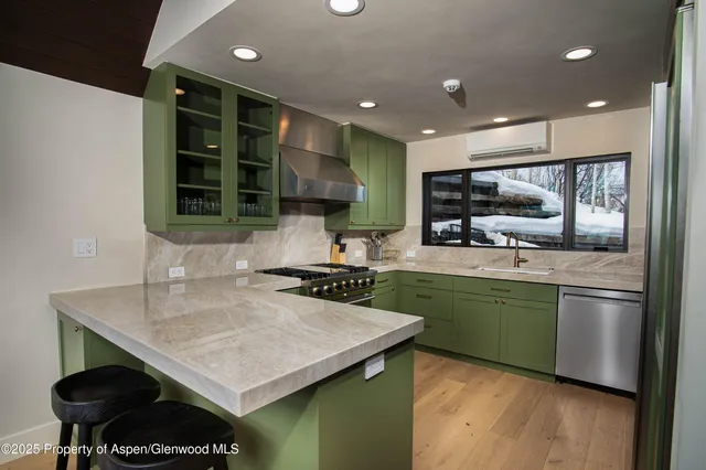 a kitchen with stainless steel appliances granite countertop a sink counter space cabinets and wooden floor