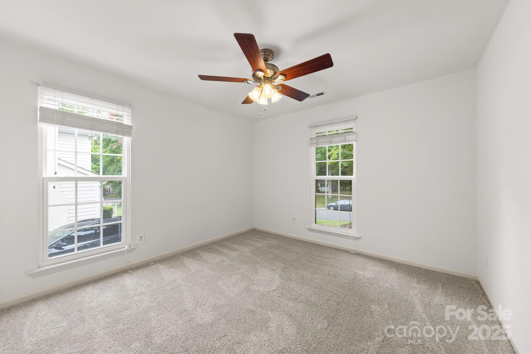 8806 Golf Ridge Drive Charlotte, NC 28277 - Photo 13 of 22 an empty room with windows and fan