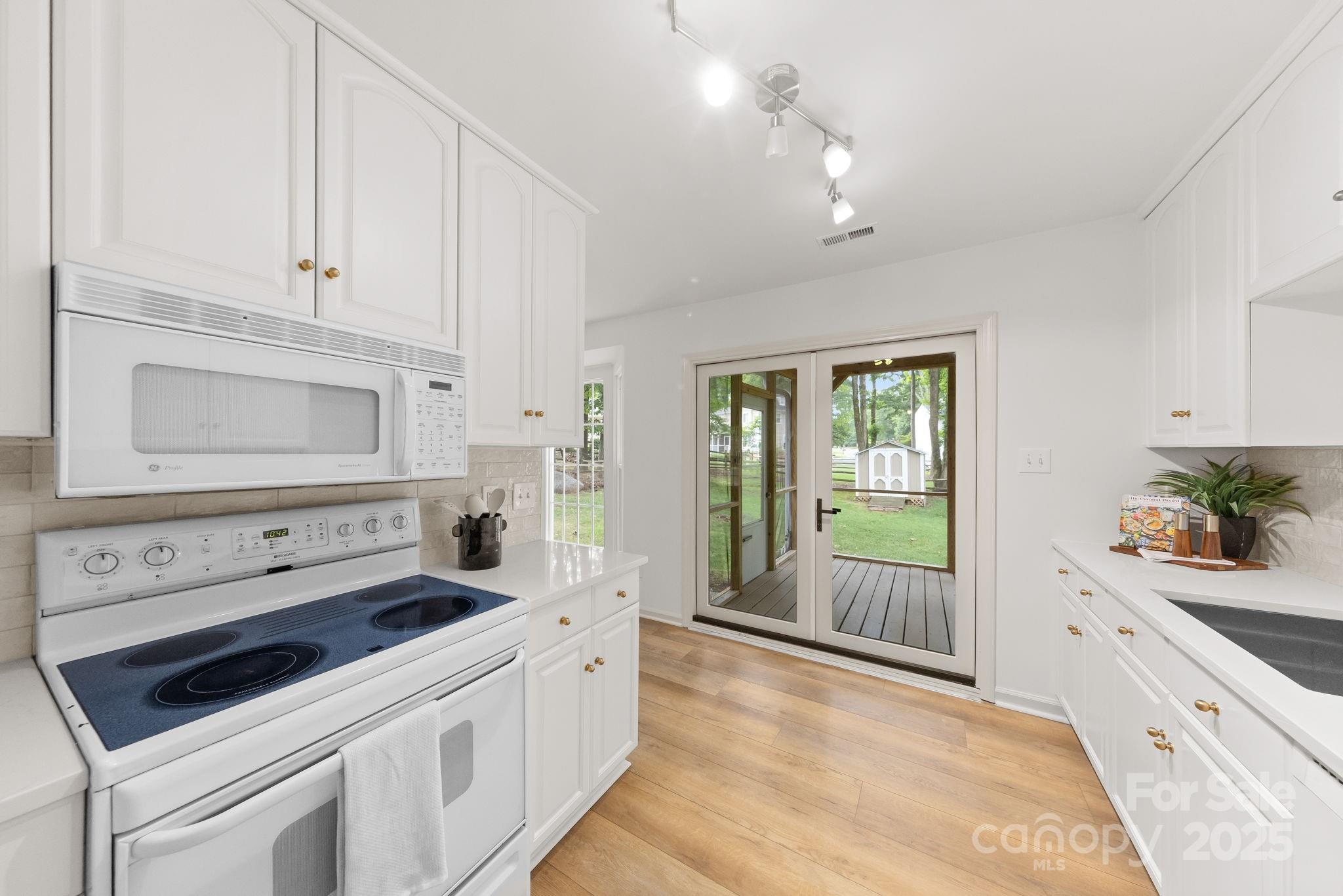 8806 Golf Ridge Drive Charlotte, NC 28277 - Photo 8 of 22 a kitchen with white cabinets and appliances
