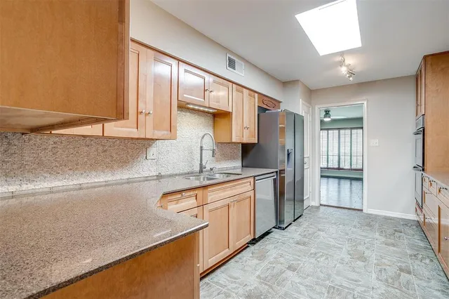 a kitchen with stainless steel appliances granite countertop a stove a sink and a refrigerator
