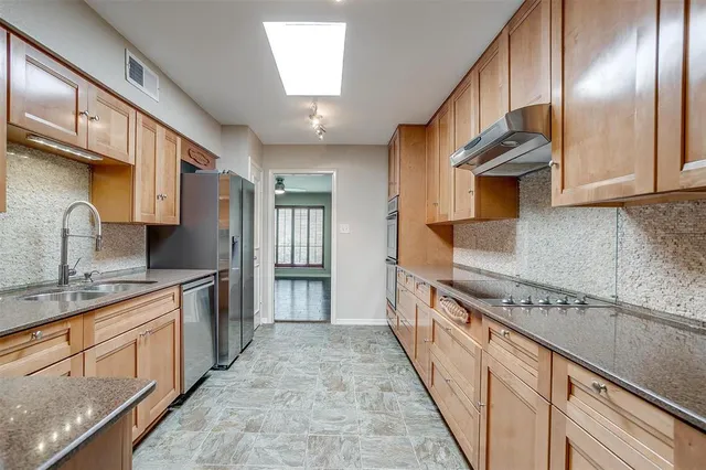 a kitchen with stainless steel appliances granite countertop a sink stove and cabinets