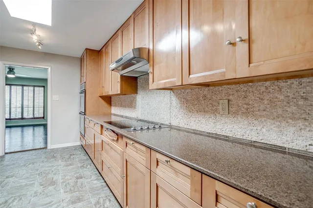 a kitchen with stainless steel appliances granite countertop a sink and a refrigerator