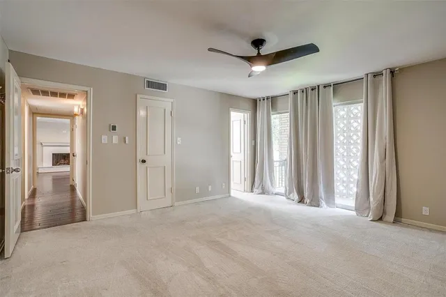 a view of a livingroom with a chandelier fan and windows