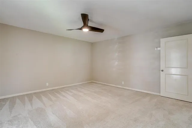 a view of an empty room with a ceiling fan