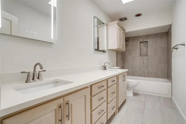 a bathroom with a sink double vanity granite tub shower and a mirror