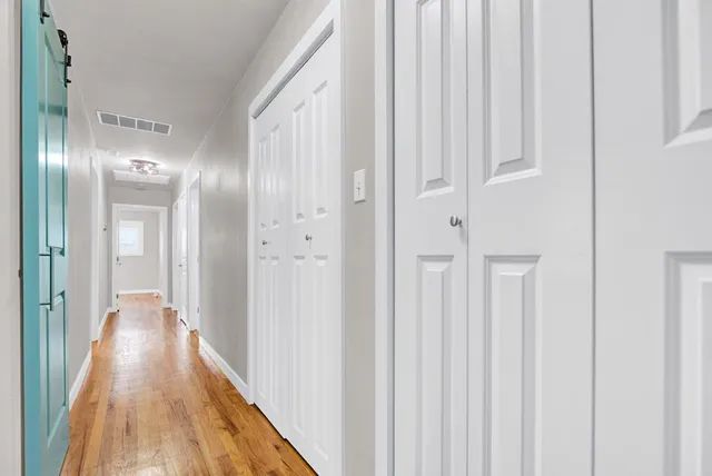 a view of a hallway with wooden floor