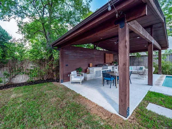 a view of a backyard with table and chairs under an umbrella