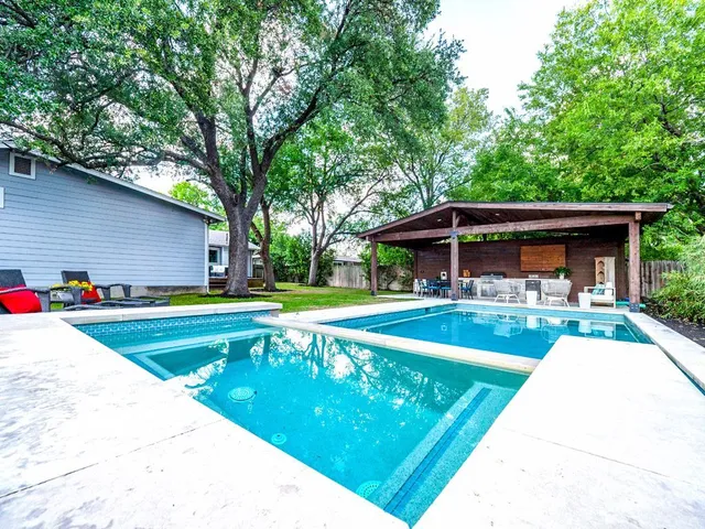 a view of a house with swimming pool and sitting area