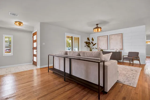 a living room with furniture and a wooden floor