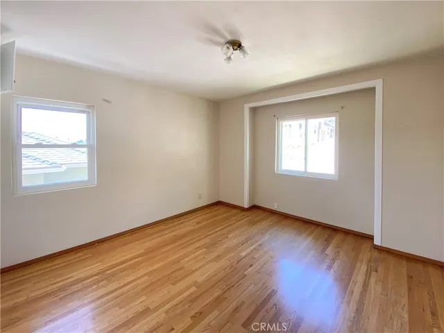 a view of an empty room window and wooden floor
