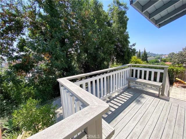 a view of balcony with wooden floor and fence