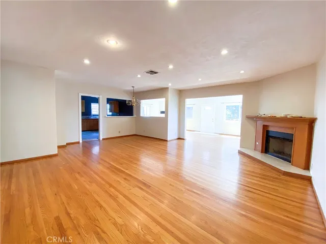a view of empty room with wooden floor and fireplace