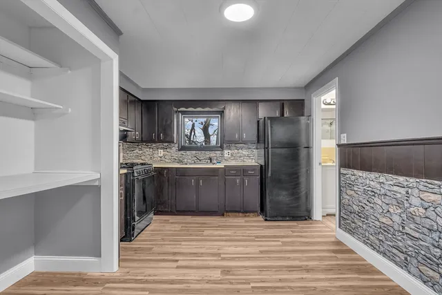 a kitchen with stainless steel appliances kitchen island granite countertop a refrigerator and a sink