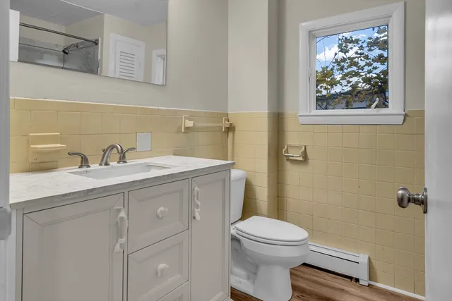 a bathroom with a toilet a sink and mirror