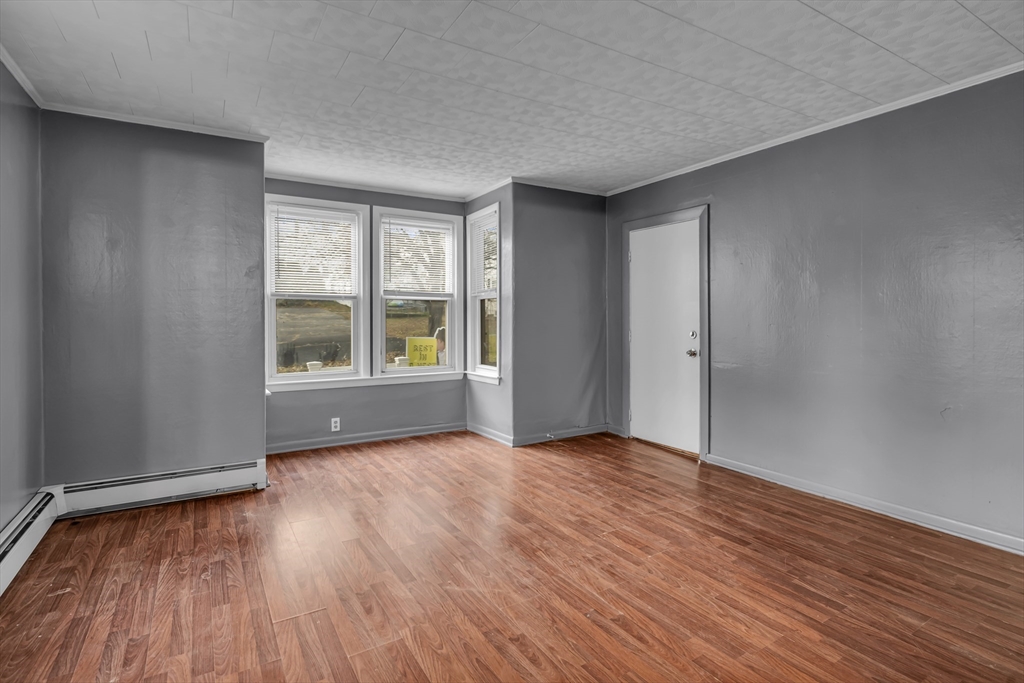 13 Pacific Street, Unit 1 Fitchburg, MA 01420 - Photo 3 of 14 a view of an empty room with window and wooden floor