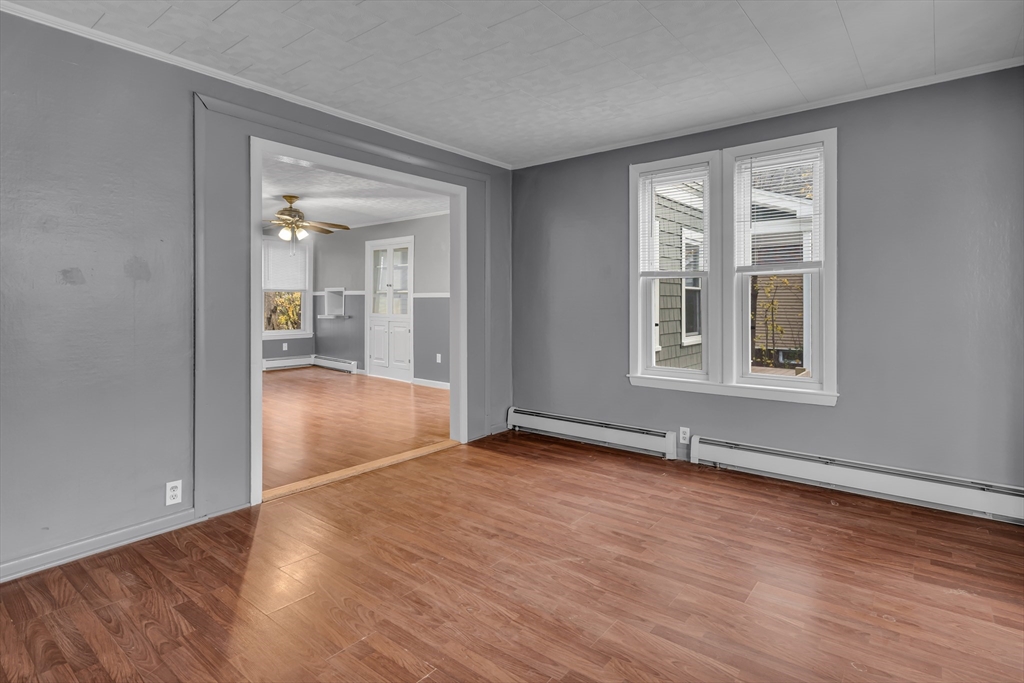 13 Pacific Street, Unit 1 Fitchburg, MA 01420 - Photo 4 of 14 a view of an empty room with wooden floor and a window
