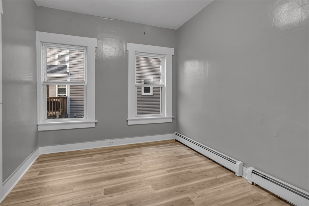 13 Pacific Street, Unit 1 Fitchburg, MA 01420 - Photo 7 of 14 a view of an empty room with wooden floor and a window