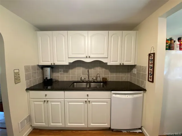 a kitchen with granite countertop a sink and cabinets