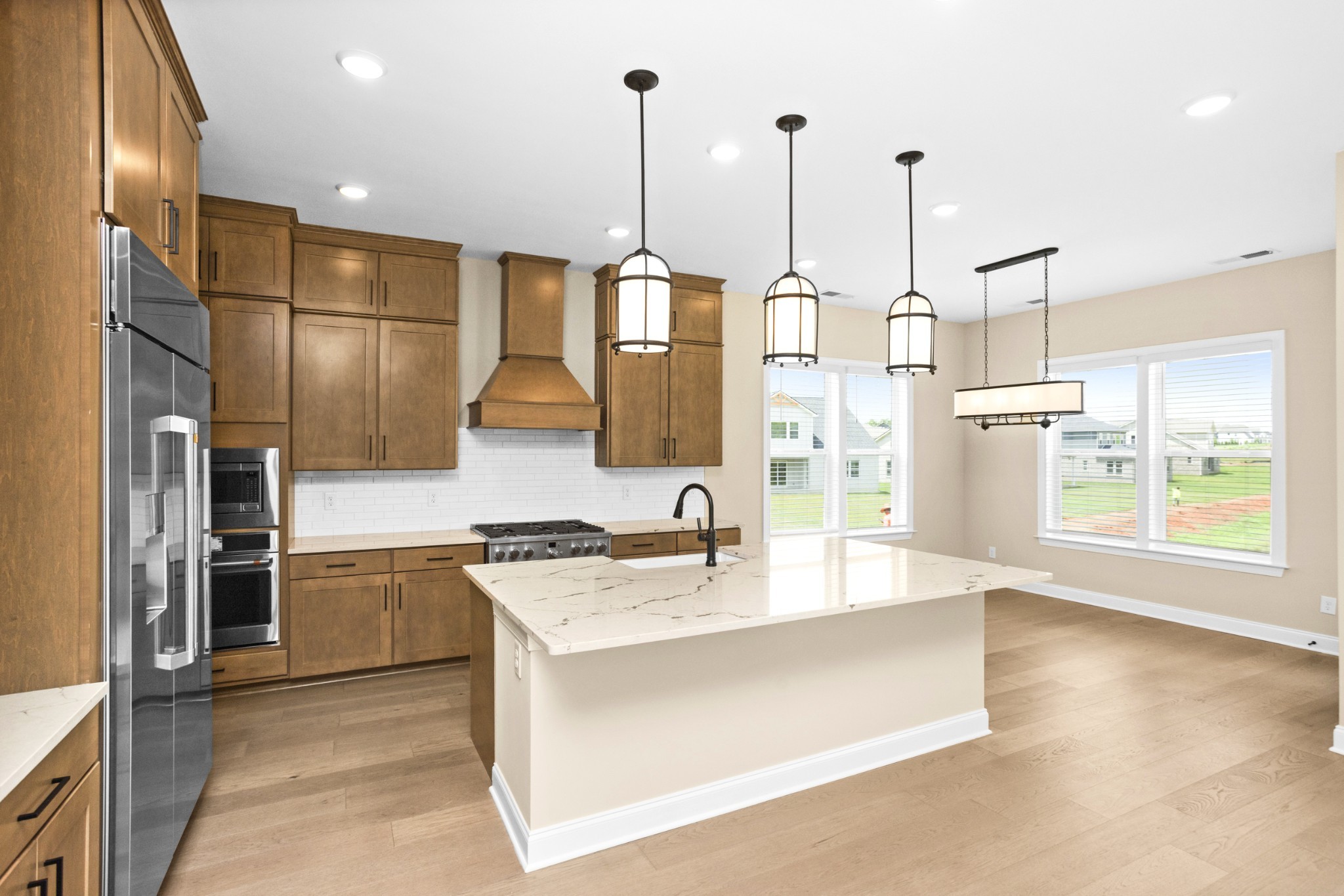 7004 Thunderhead Way Spring Hill, TN 37174 - Photo 17 of 52 a kitchen with stainless steel appliances granite countertop a sink a stove and a refrigerator