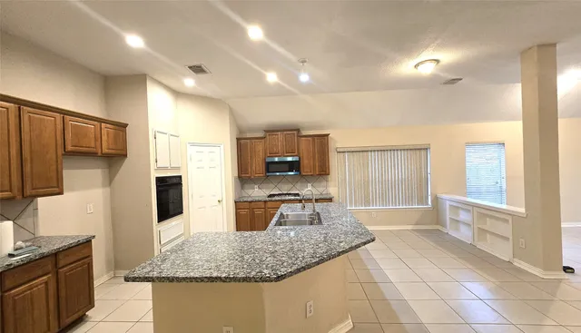 a kitchen with stainless steel appliances granite countertop a sink stove and refrigerator