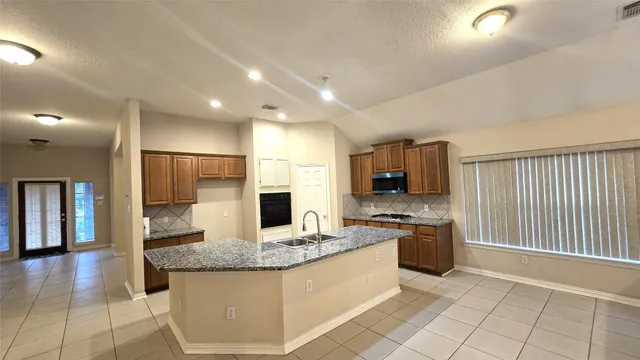 a kitchen with stainless steel appliances granite countertop a sink and cabinets