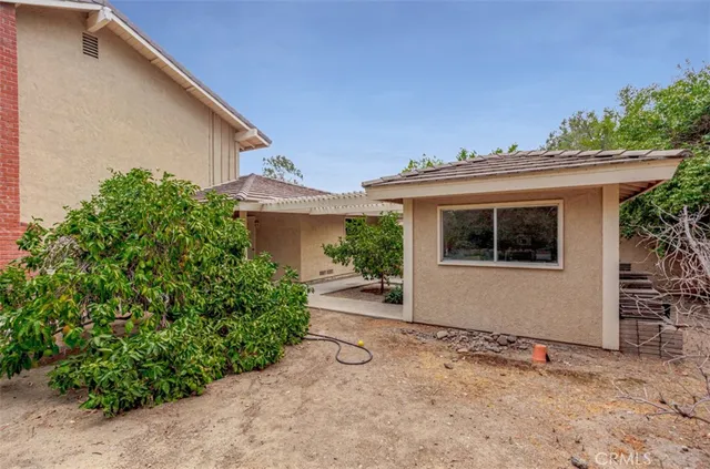 a view of a house with a yard and potted plants