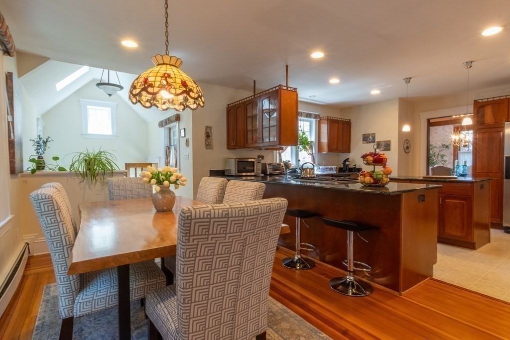 182 Marked Tree Road Needham, MA 02492 - Photo 10 of 21 a kitchen with a table chairs and a chandelier