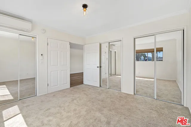 an empty room with closet and windows