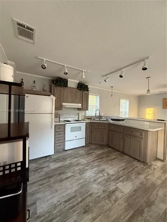 a kitchen with stainless steel appliances kitchen island granite countertop a refrigerator and a stove top oven