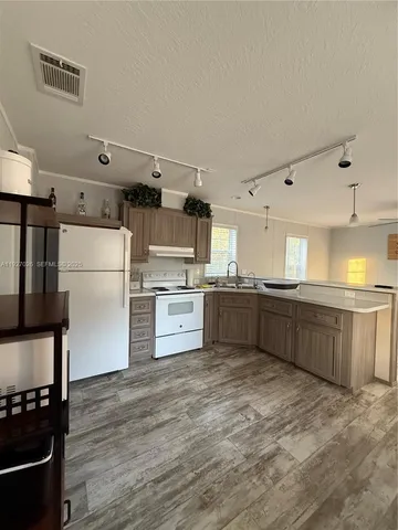 a kitchen with stainless steel appliances kitchen island granite countertop a refrigerator and a stove top oven