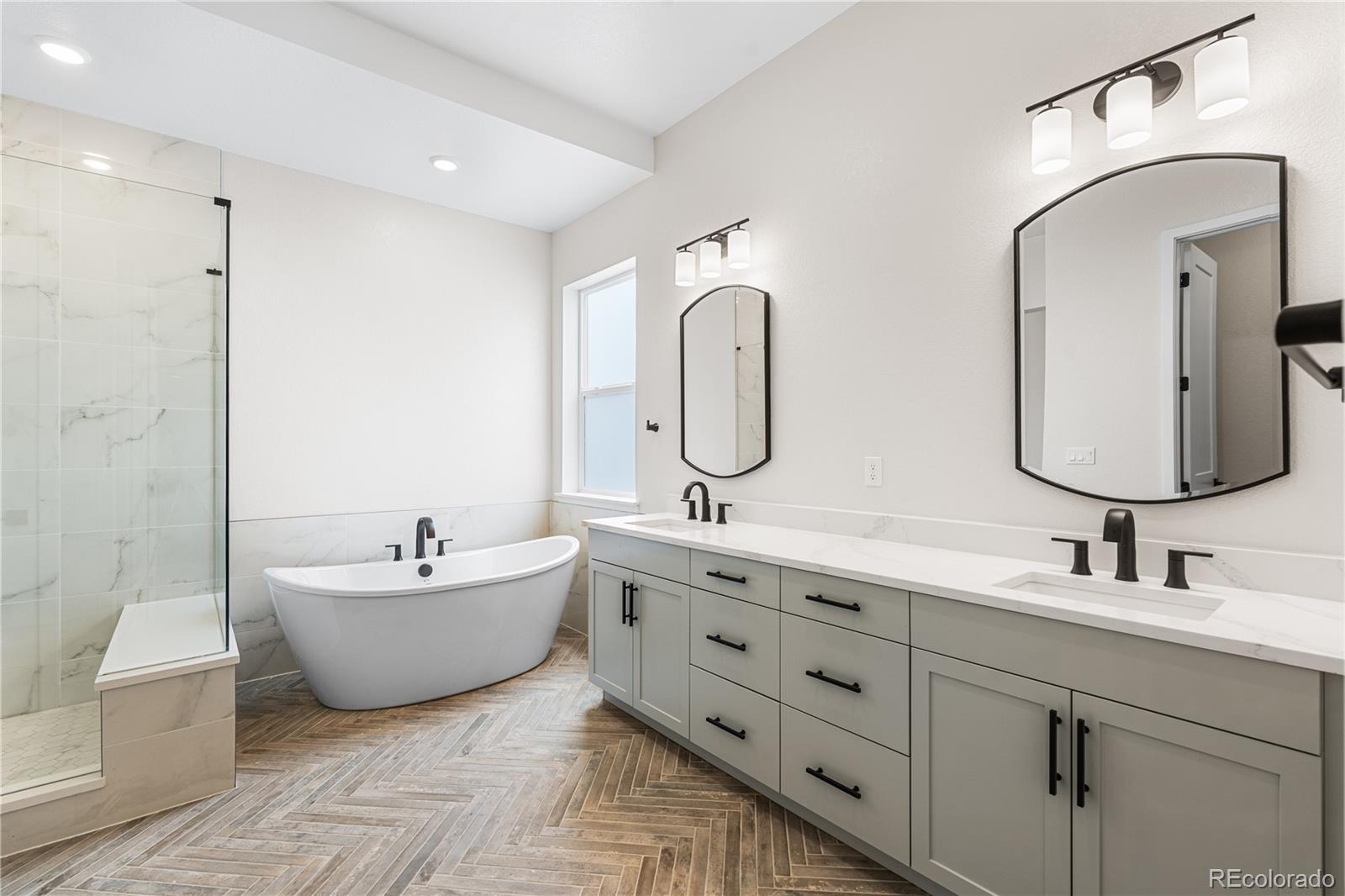 7392 Timberstone Street Castle Pines, CO 80108 - Photo 35 of 42 a bathroom with a double vanity sink mirror and bathtub