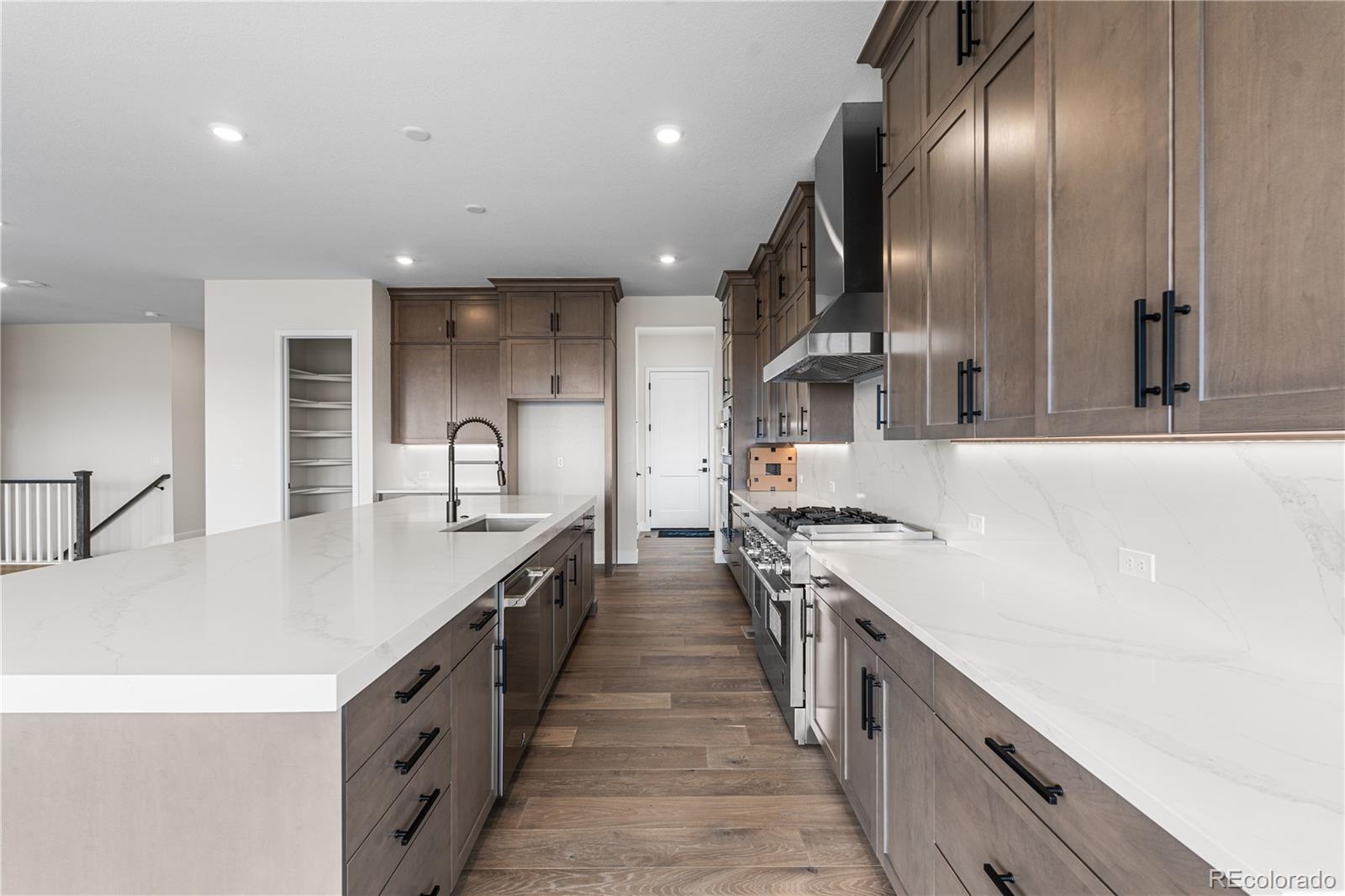 7392 Timberstone Street Castle Pines, CO 80108 - Photo 9 of 42 a large kitchen with stainless steel appliances granite countertop a lot of counter space and wooden floor