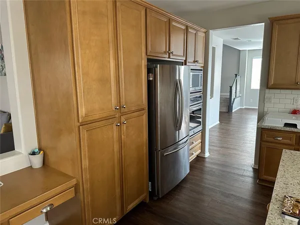 a view of kitchen with wooden floor electronic appliances and furniture