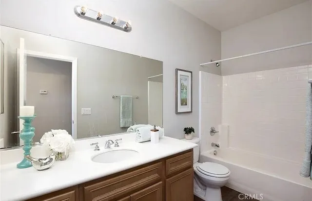 a bathroom with a granite countertop sink mirror toilet and bathtub