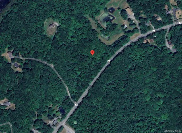 an aerial view of residential houses with outdoor space and trees