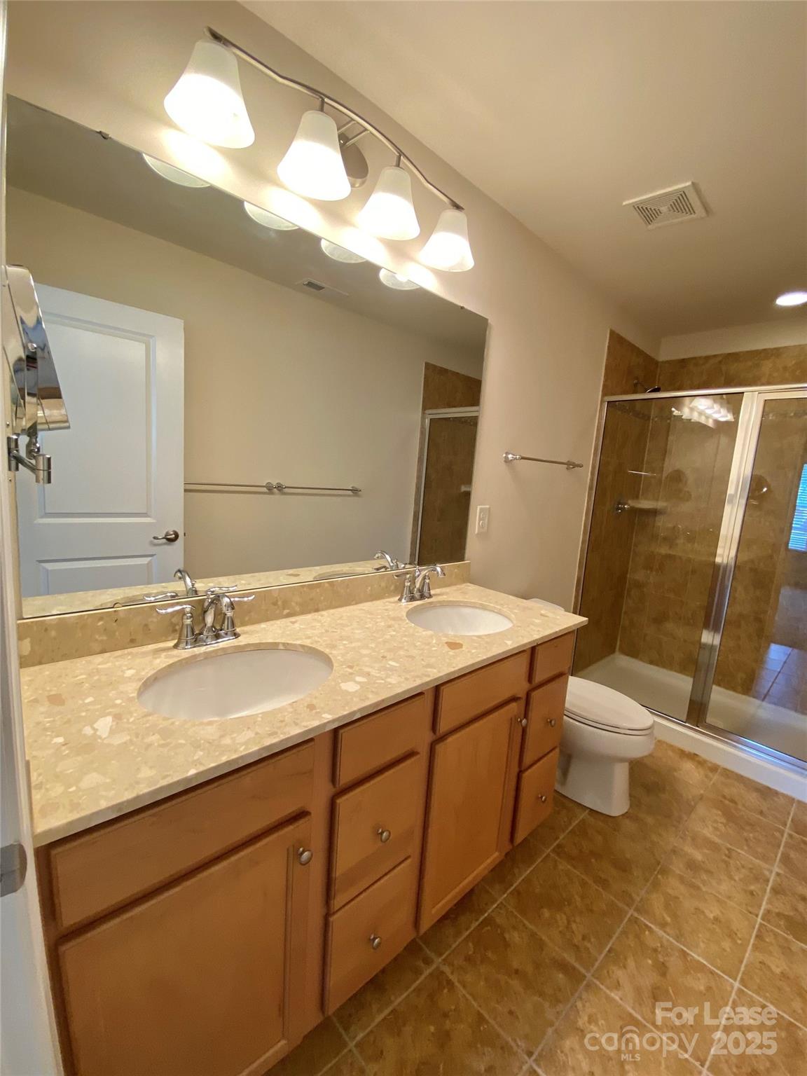2601 Silverthorn Drive Charlotte, NC 28273 - Photo 23 of 36 a bathroom with a granite countertop sink a toilet and a mirror