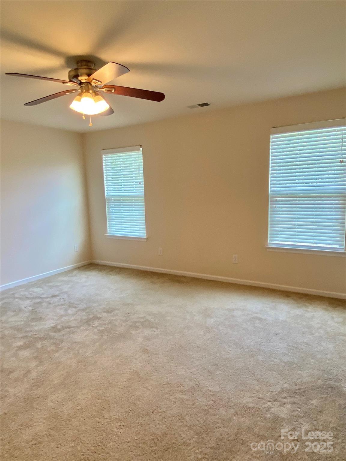 2601 Silverthorn Drive Charlotte, NC 28273 - Photo 26 of 36 an empty room with a chandelier fan and windows