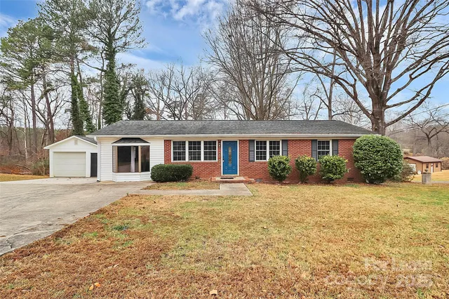 a front view of a house with a yard and trees