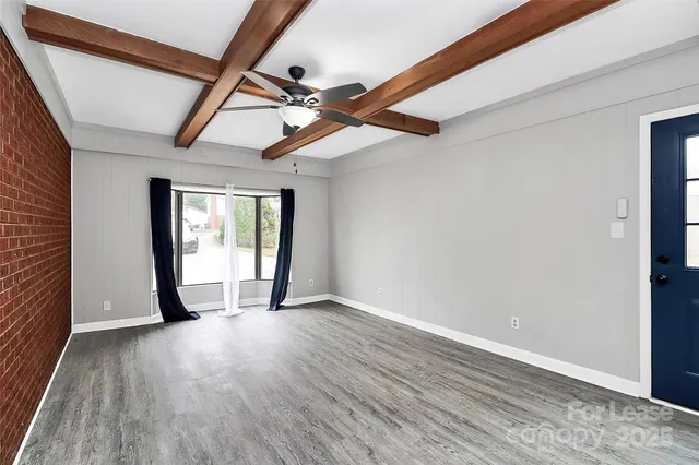 a view of a room with wooden floor and windows