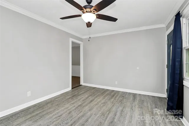 an empty room with wooden floor a ceiling fan and closet