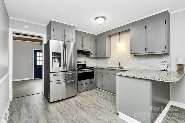 a kitchen with stainless steel appliances granite countertop a refrigerator and a stove top oven