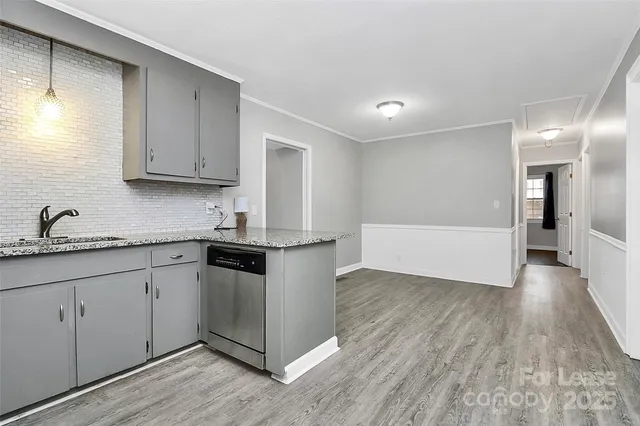 a kitchen with granite countertop white cabinets and wooden floor