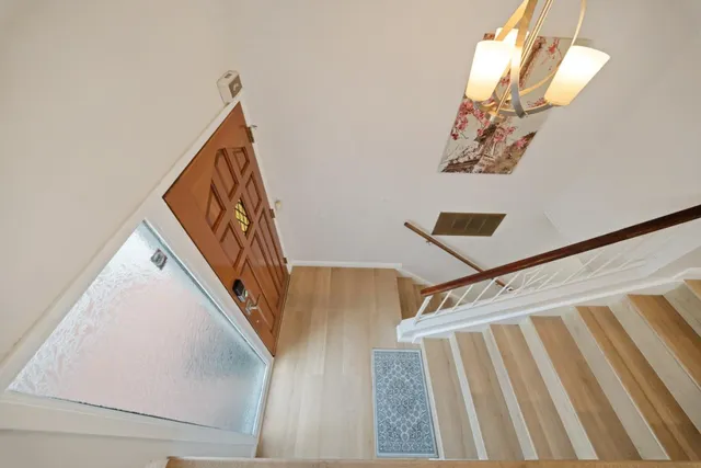 a view of staircase with lots of frames on wall and a window
