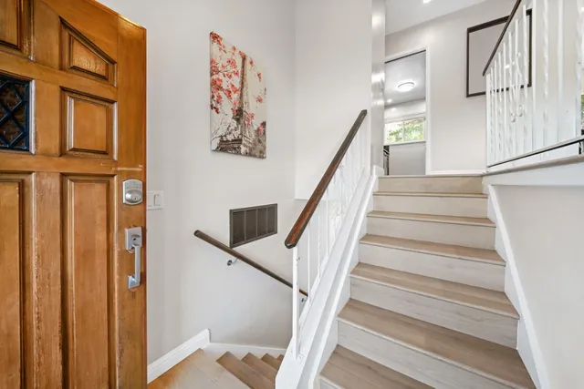 a view of a hallway with wooden floor and staircase