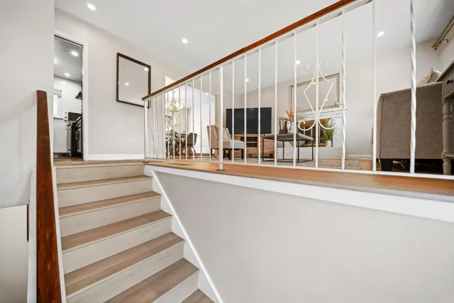 a view of a hallway with wooden floor and stairs