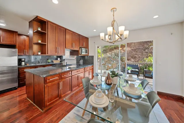 a kitchen with granite countertop stainless steel appliances cabinets a sink and a window