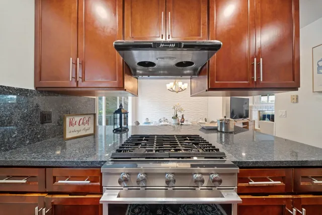a view of a dining room with furniture a kitchen and chandelier