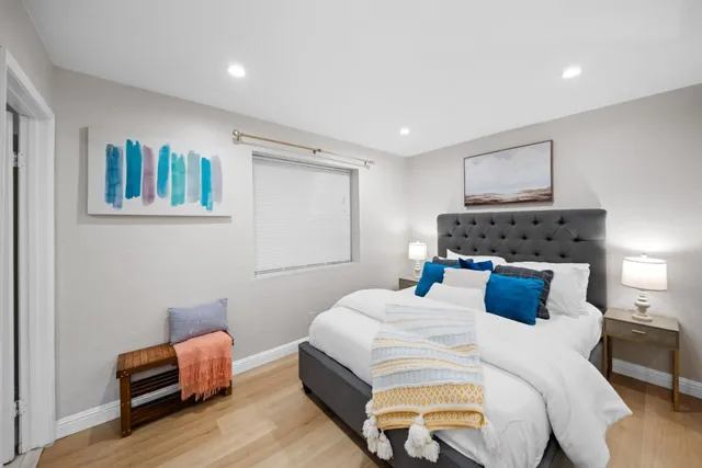 a bedroom with a large bed and a wooden floor