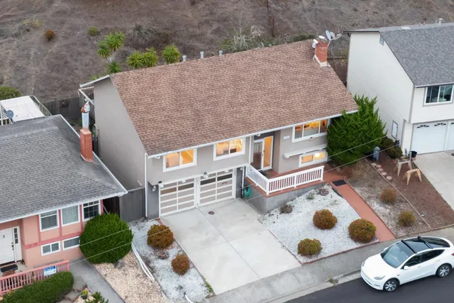 an aerial view of a house with backyard space and patio